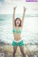 A woman in a bikini standing in the ocean.