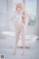 A woman in a white lingerie posing in a bathtub.