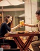 A man and a woman sitting at a table with a glass of beer.