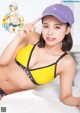 A woman in a yellow bikini and a purple hat.