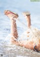 A woman in a bikini laying in the water with her feet in the air.