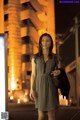 A woman standing in the middle of a street at night.