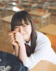 A young woman sitting at a desk in a classroom.